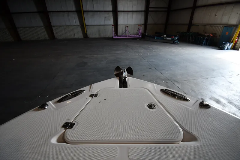Slide: The Image of Bow view of a 2015 Edgewater 320CC boat in a spacious warehouse. - 25