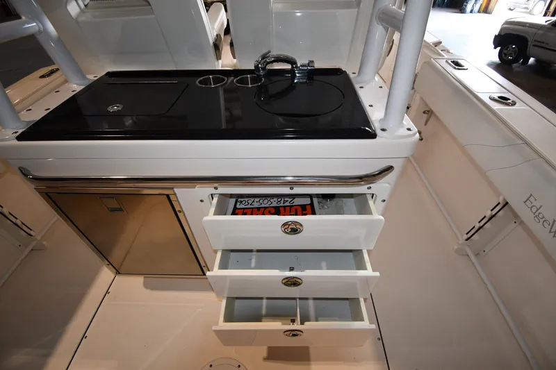 Slide: The Image of 2015 Edgewater 320CC boat interior with sink, storage drawers, and stainless steel accents. - 18