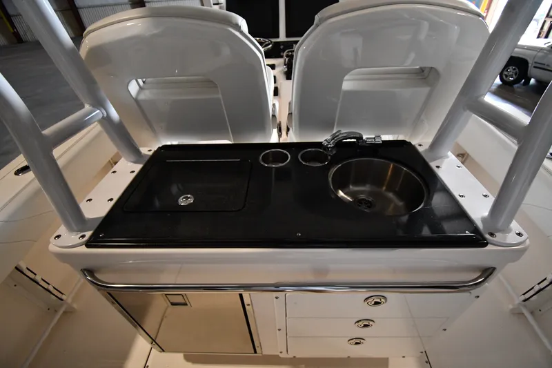 Slide: The Image of 2015 Edgewater 320CC boat interior with sink and storage area. - 16