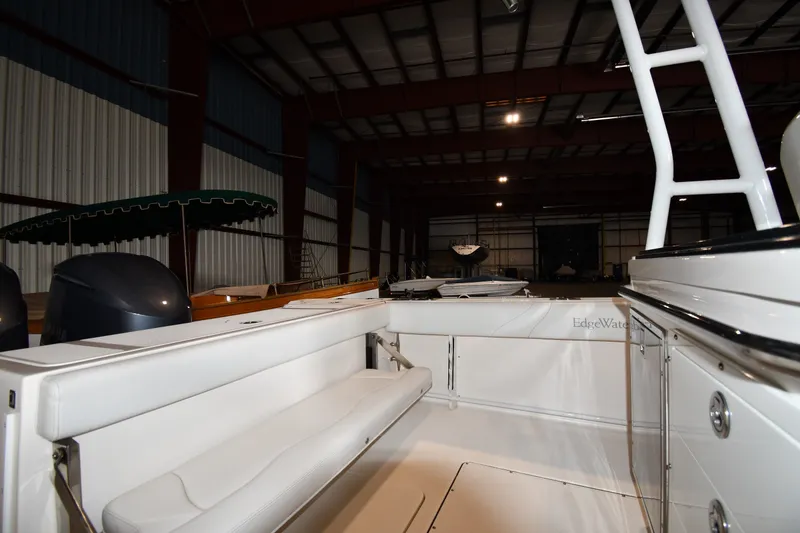 Slide: The Image of 2015 Edgewater 320CC boat interior in a warehouse, showcasing seating and storage. - 15