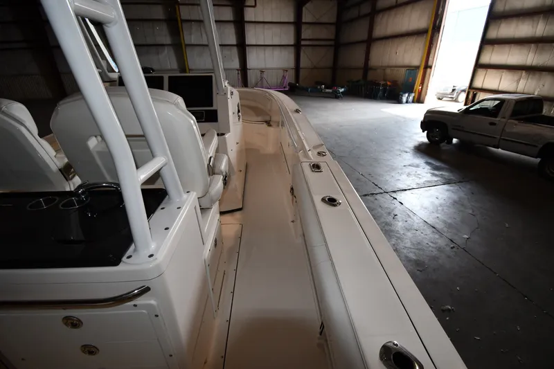Slide: The Image of 2015 Edgewater 320CC boat interior in a warehouse with a parked truck nearby. - 19