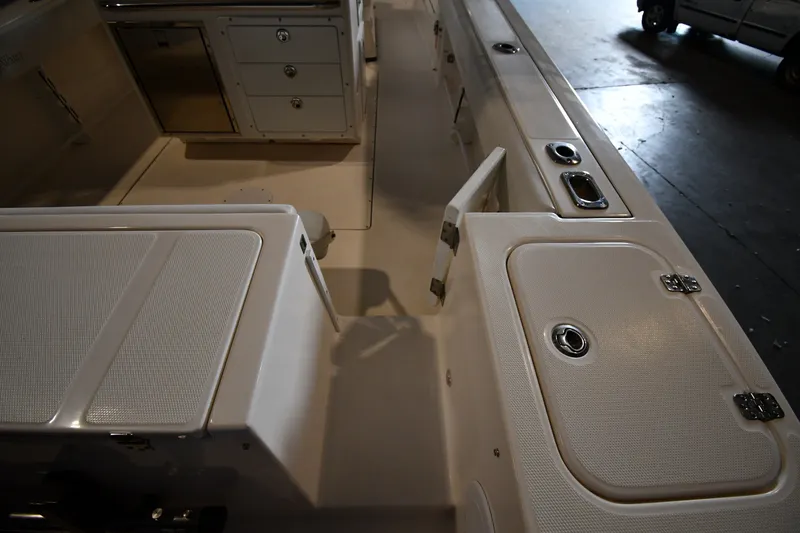 Slide: The Image of Interior view of a 2015 Edgewater 320CC boat, featuring storage compartments and seating. - 30