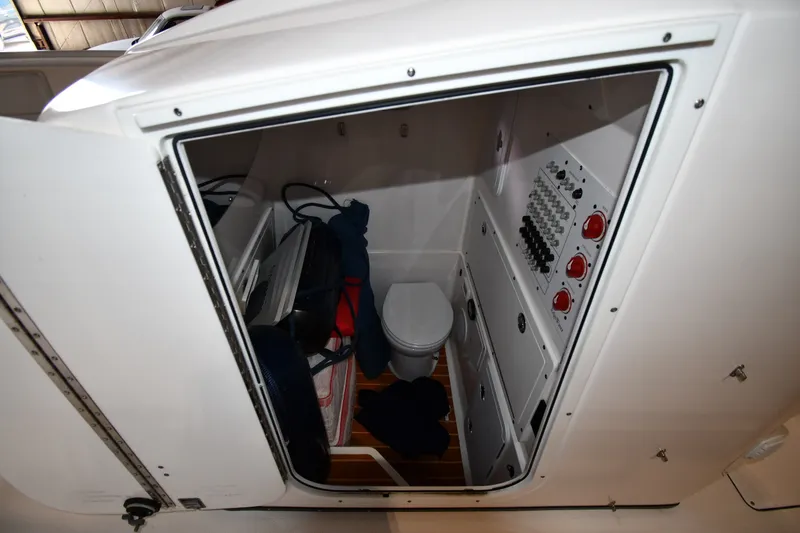 Slide: The Image of Interior of 2015 Edgewater 320CC boat showing compact cabin with toilet and control panel. - 37