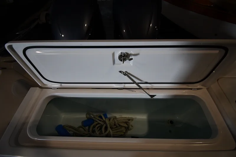 Slide: The Image of Open storage compartment on 2015 Edgewater 320CC boat with rope inside. - 32