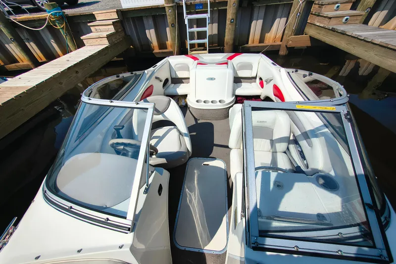 Slide: The Image of 2004 Stingray 185 LS/LX boat interior with white and red seating, docked at a marina. - 8