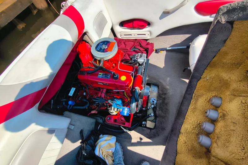 Slide: The Image of 2004 Stingray 185 LS/LX boat engine compartment with red engine and interior details. - 11