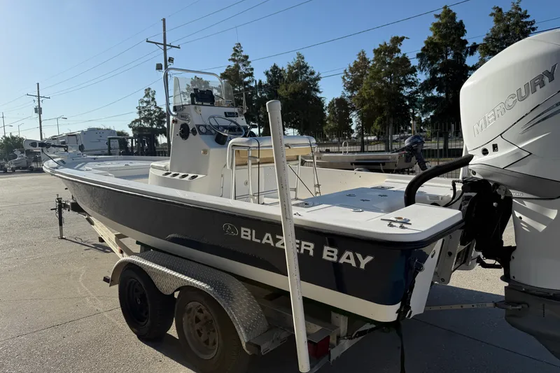 Slide: The Image of 2005 Blazer Bay 2220 Fisherman boat with Mercury engine on trailer in sunny outdoor setting. - 5