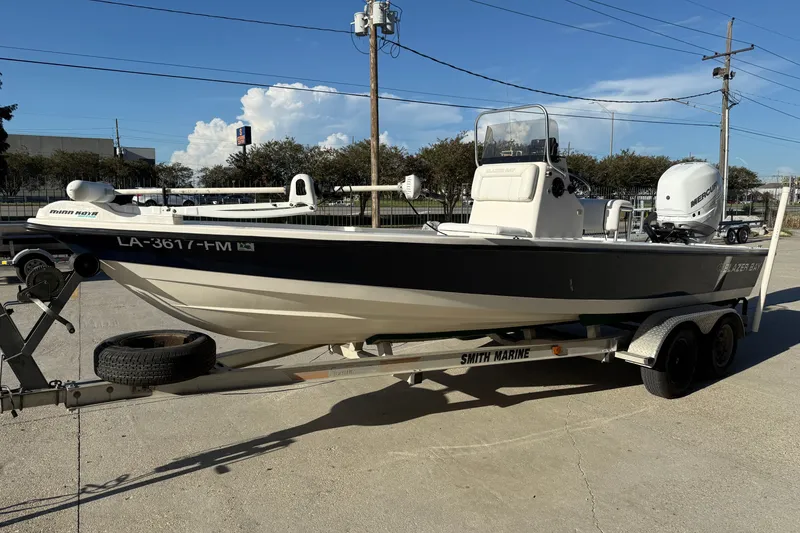 Slide: The Image of 2005 Blazer Bay 2220 Fisherman boat on trailer, featuring a Minn Kota trolling motor. - 8