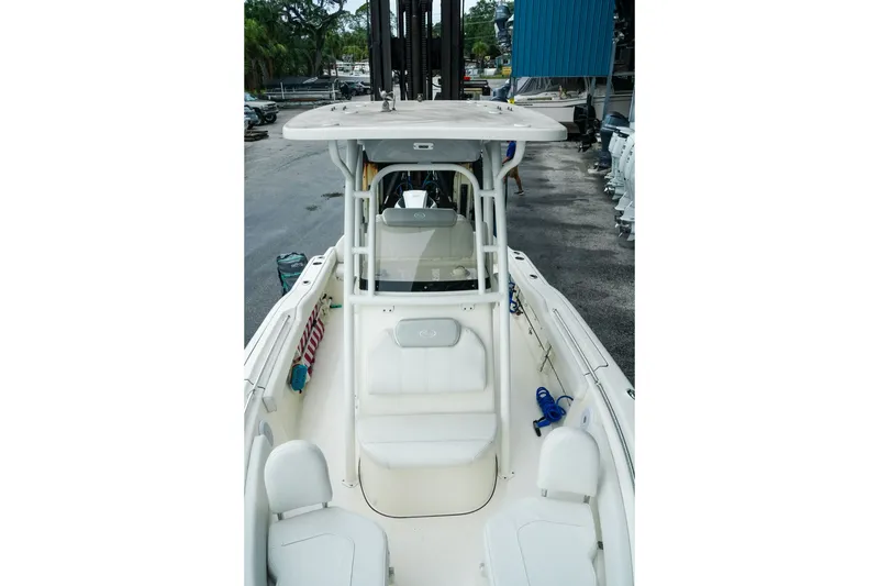 Slide: The Image of 2022 Key West 219 FS boat interior, featuring seating and console, docked at a marina. - 18