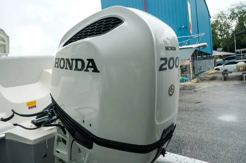Slide: The Image of 2022 Key West 219 FS boat with Honda 200 outboard motor in a marina setting. - 40
