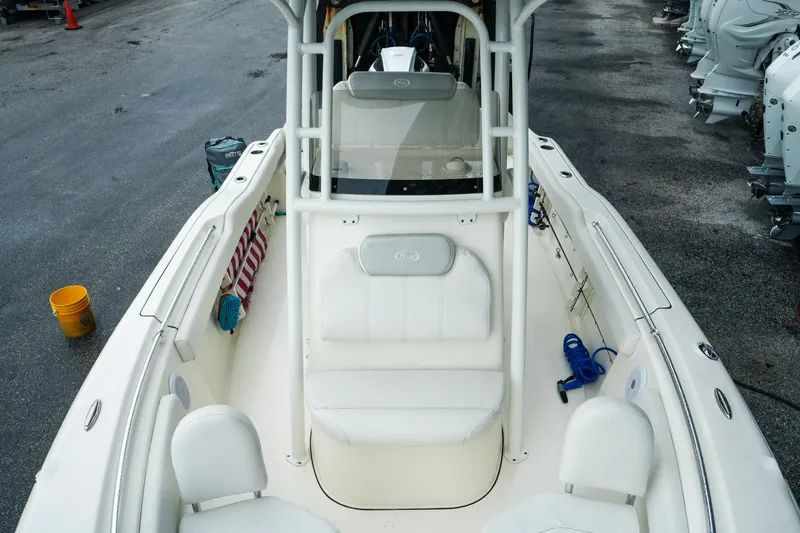 Slide: The Image of 2022 Key West 219 FS boat interior with seating and storage, docked on a wet surface. - 16