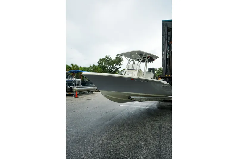 Slide: The Image of 2022 Key West 219 FS boat on trailer, parked outdoors on a cloudy day. - 49