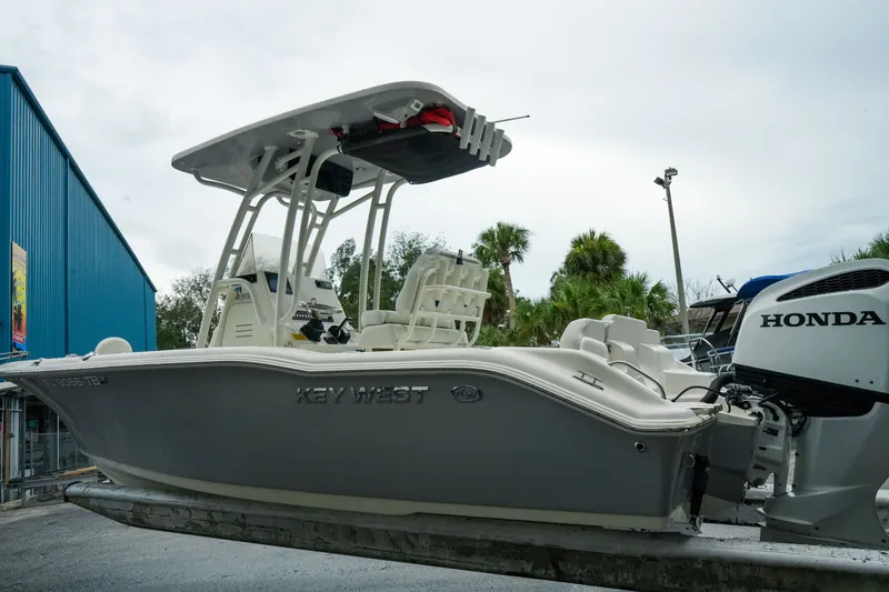 Slide: The Image of 2022 Key West 219 FS boat with Honda engine, parked outdoors near blue building. - 45