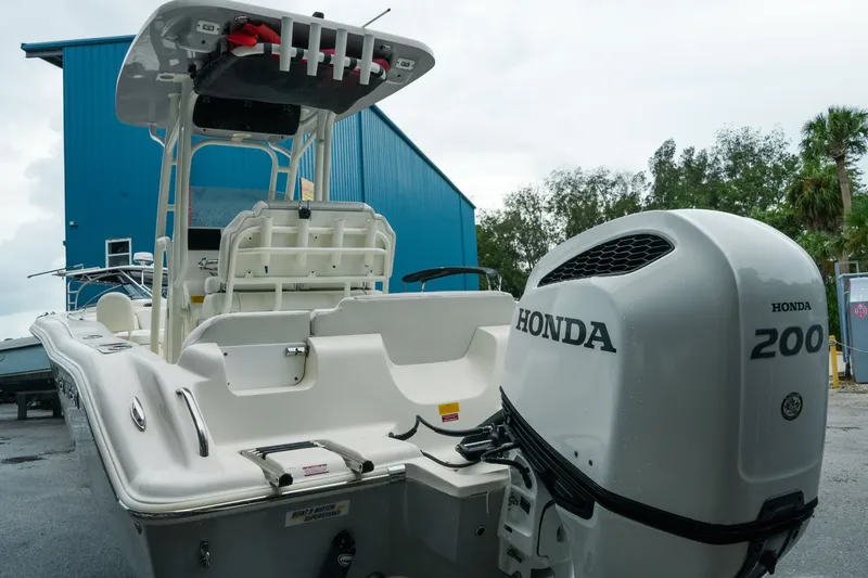 Slide: The Image of 2022 Key West 219 FS boat with Honda 200 engine, docked near blue building. - 47