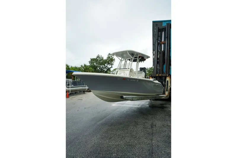 Slide: The Image of 2022 Key West 219 FS boat being transported on a forklift in a marina setting. - 48