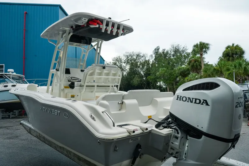 Slide: The Image of 2022 Key West 219 FS boat with Honda engine, docked outdoors near blue building. - 46