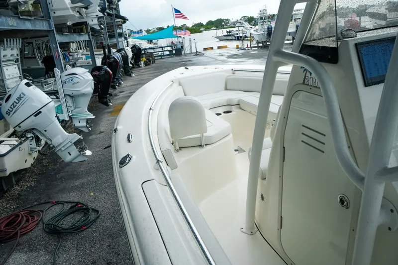 Slide: The Image of 2022 Key West 219 FS boat docked, featuring spacious seating and Suzuki outboard motors. - 14