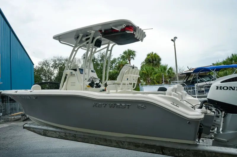 Slide: The Image of 2022 Key West 219 FS boat with Honda outboard motor, docked outdoors. - 44
