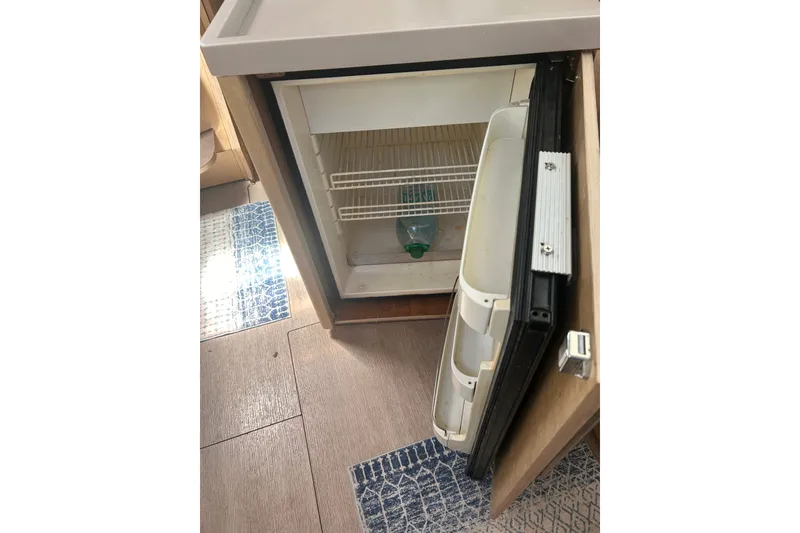 Slide: The Image of Open refrigerator inside 2020 Beneteau Oceanis 461 yacht, showing interior shelves and door compartments. - 24
