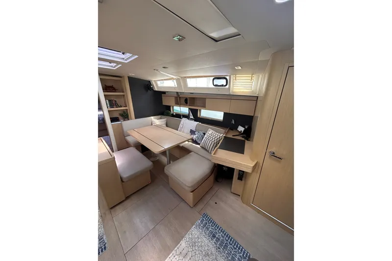 Slide: The Image of Interior of 2020 Beneteau Oceanis 461 yacht, featuring modern dining area and cozy seating. - 21