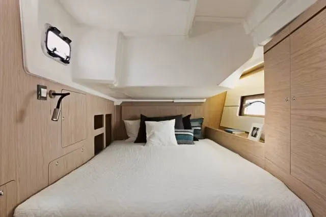 Slide: The Image of Luxurious cabin interior of 2010 Oceanis 46.1 yacht with cozy bedding and wooden accents. - 8