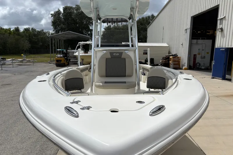 Slide: The Image of 2025 Key West 239 FS boat, white exterior, docked near a warehouse. - 11