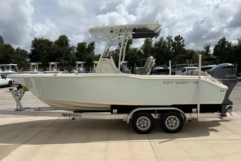 Slide: The Image of 2025 Key West 239 FS boat on trailer, parked outdoors under cloudy sky. - 5