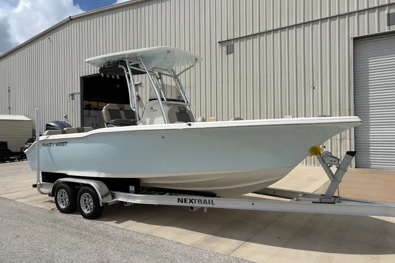 Slide: The Image of 2025 Key West 239 FS boat on trailer outside a large warehouse. - 3