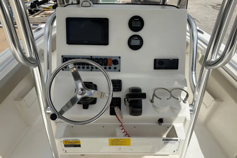 Slide: The Image of 2025 Key West 239 FS boat dashboard with steering wheel, controls, and gauges. - 17
