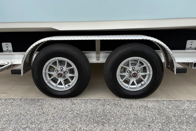 Slide: The Image of Trailer wheels of a 2025 Key West 239 FS boat on a paved surface. - 31