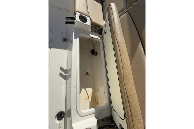 Slide: The Image of 2018 Scout 251 XSS boat interior storage compartment with beige seating. - 20