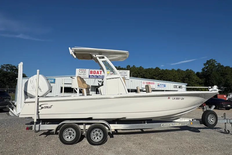 The Image of 2018 Scout 251 XSS boat on trailer at dealership, clear sky background. - 1