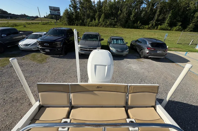 Slide: The Image of 2018 Scout 251 XSS boat parked near cars in a lot, surrounded by greenery. - 14