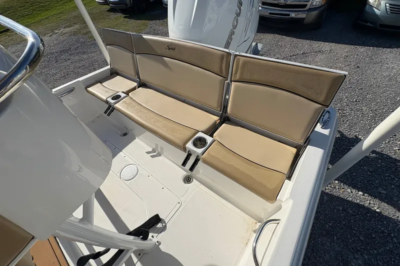 Slide: The Image of 2018 Scout 251 XSS boat seating area with beige cushions and cup holders. - 15