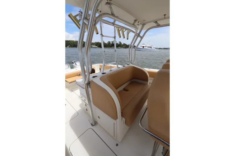Slide: The Image of 2009 Hydra-Sports 4100 VSF boat interior with tan seating and rod holders on a calm waterway. - 31
