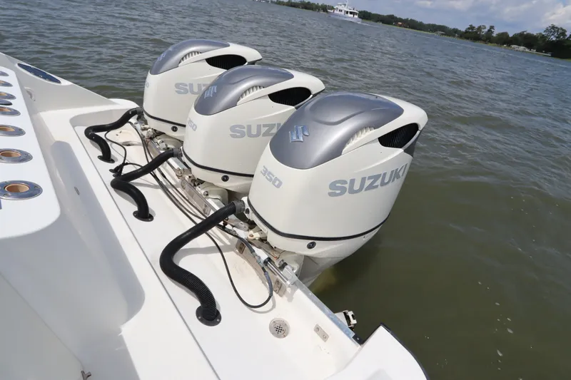 Slide: The Image of Triple Suzuki outboard engines on a 2009 Hydra-Sports 4100 VSF boat in water. - 13