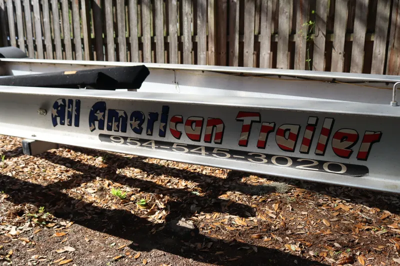 Slide: The Image of Trailer with "All American Trailer" branding, parked on leaf-covered ground. - 73