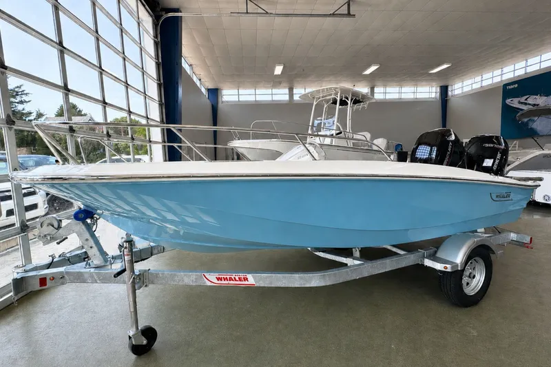 Slide: The Image of 2027 Boston Whaler 160 Super Sport boat in showroom, displayed on a trailer. - 3