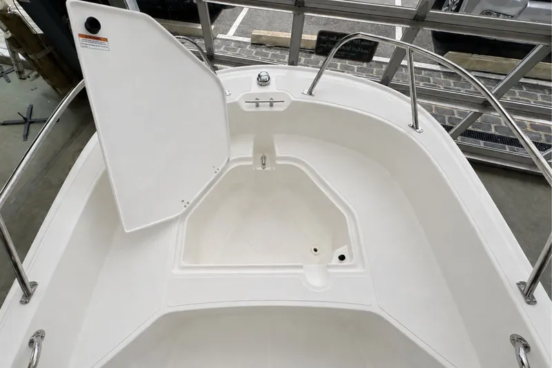 Slide: The Image of 2027 Boston Whaler 160 Super Sport boat interior with open storage compartment. - 11
