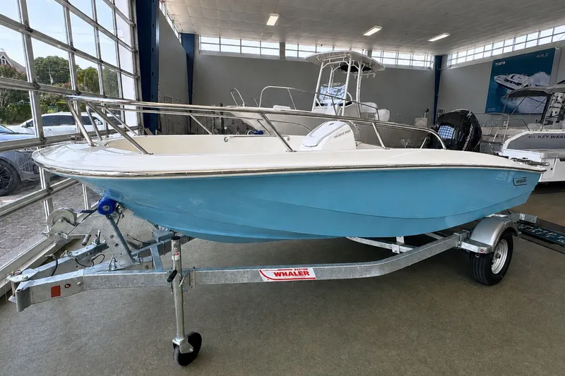 Slide: The Image of 2027 Boston Whaler 160 Super Sport boat on trailer in showroom. - 2