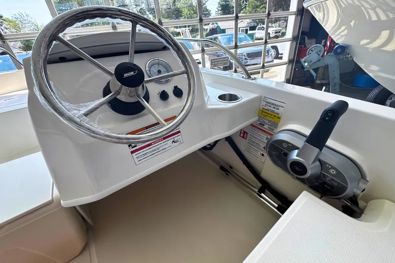 Slide: The Image of 2027 Boston Whaler 160 Super Sport boat steering console with controls and gauges. - 7