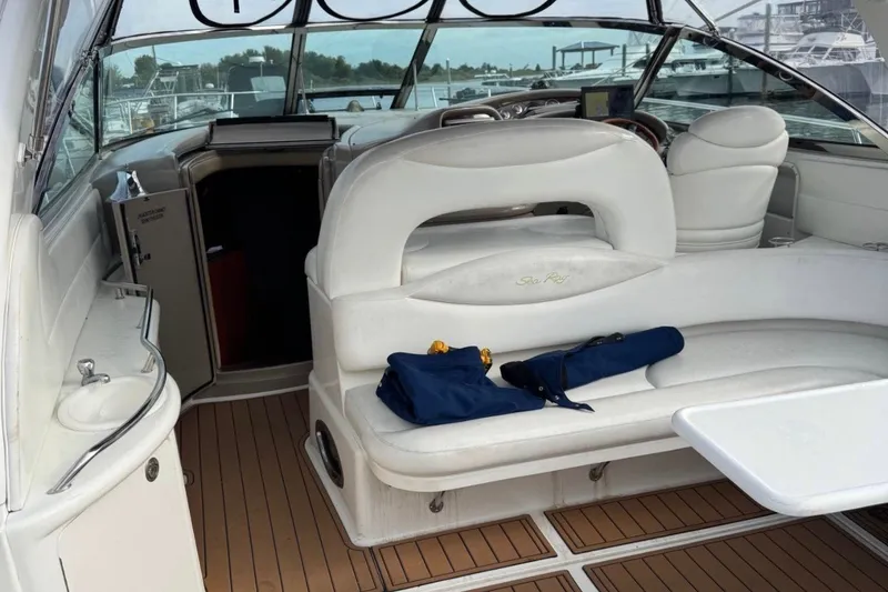 Slide: The Image of Interior of a 2000 Sea Ray 410 Sundancer yacht with white seating and wooden flooring. - 7