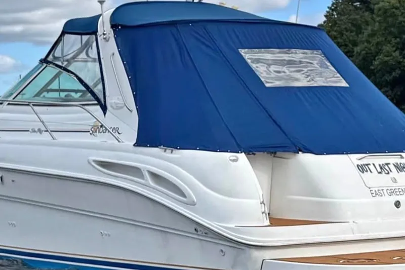 Slide: The Image of 2000 Sea Ray 410 Sundancer yacht with blue canopy, docked outdoors. - 1