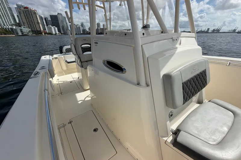 Slide: The Image of 2018 Cobia 301 Center Console boat on water with city skyline background. - 20