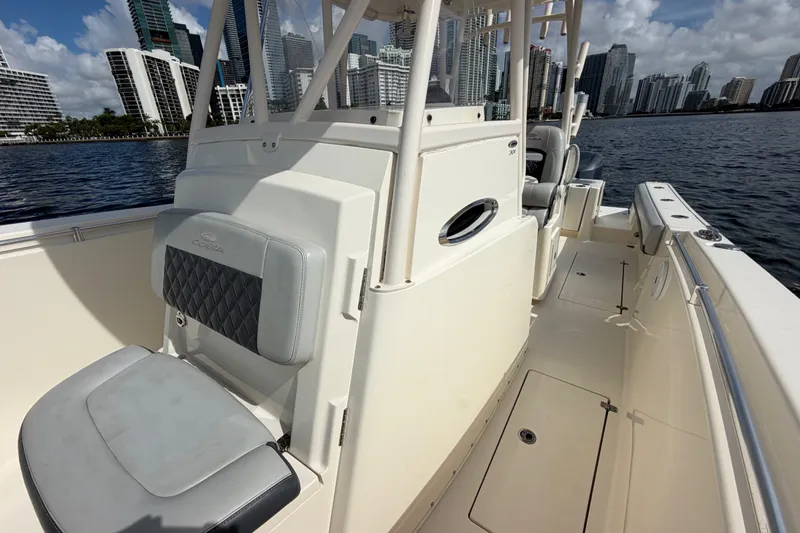 Slide: The Image of 2018 Cobia 301 Center Console boat on water with city skyline background. - 21