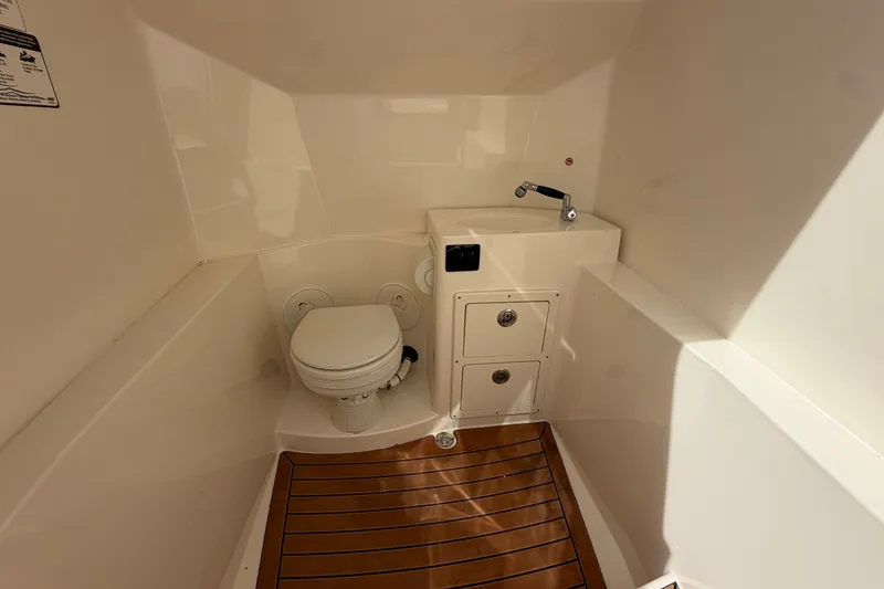 Slide: The Image of 2018 Cobia 301 Center Console boat interior with toilet and sink. - 18