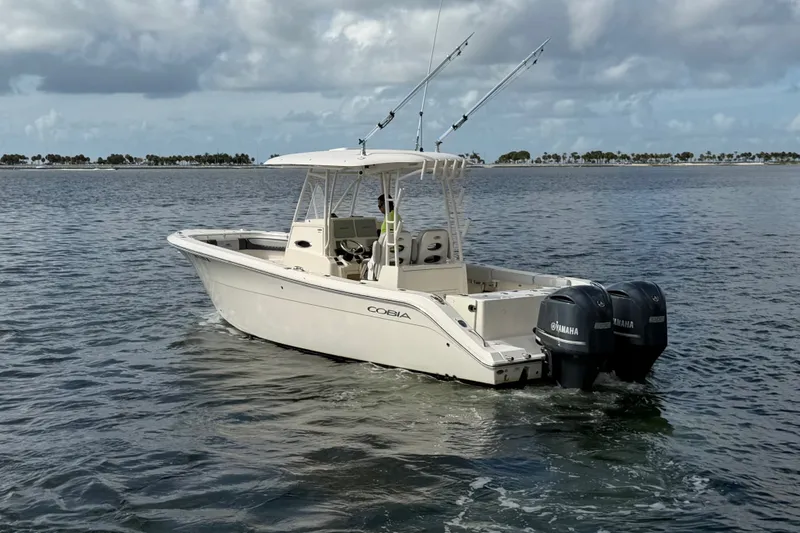Slide: The Image of 2018 Cobia 301 Center Console boat on calm water with dual Yamaha engines. - 4