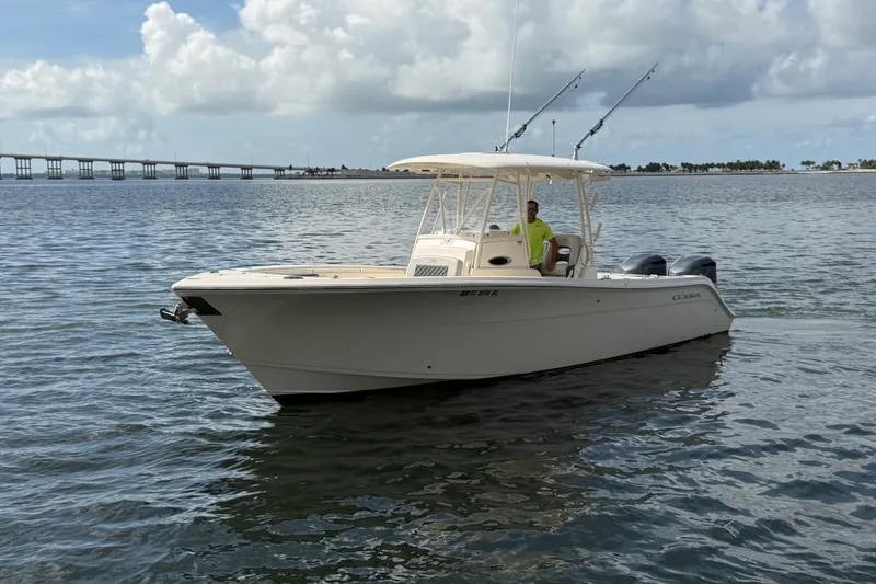 Slide: The Image of 2018 Cobia 301 Center Console boat on calm water with bridge in background. - 3