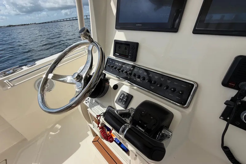 Slide: The Image of 2018 Cobia 301 Center Console boat dashboard with steering wheel and controls. - 30