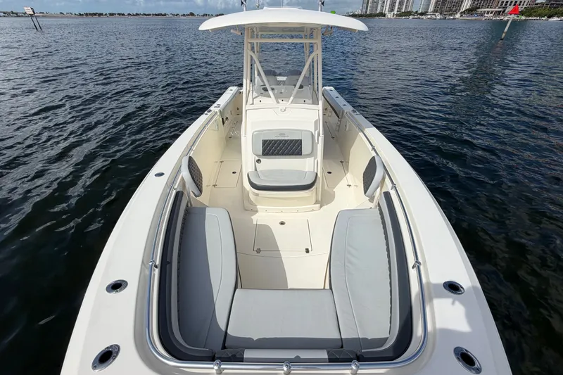 Slide: The Image of 2018 Cobia 301 Center Console boat on water, featuring spacious seating and sleek design. - 8